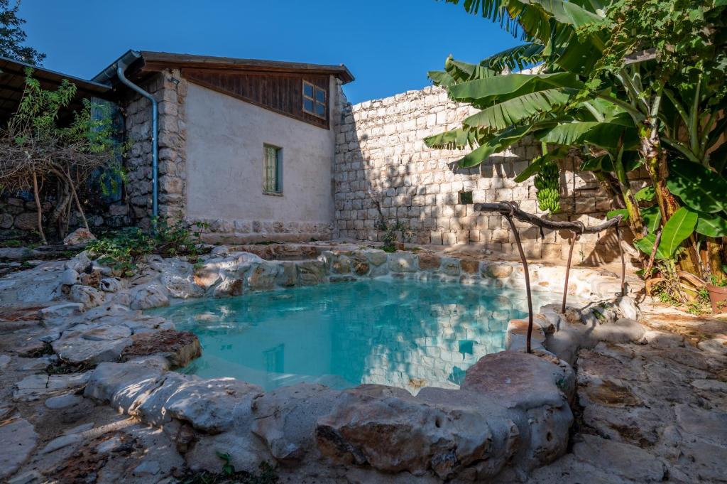 a swimming pool in front of a house at Hemdatya Stone Suites In The Galilee in Ilaniya
