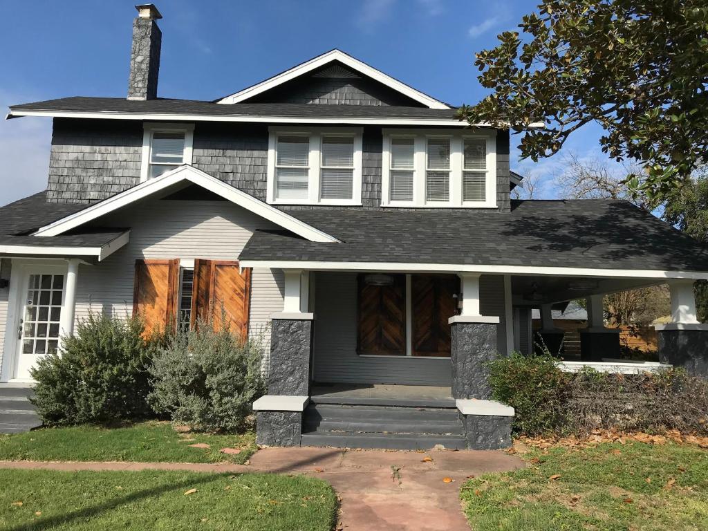 a gray house with a porch and a roof at Luxurious 3 bedroom near downtown in San Antonio