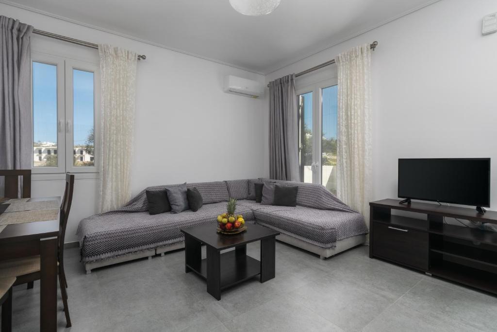een woonkamer met een bank en een flatscreen-tv bij Emanouela's apartement in the center of Adamas in Adamas