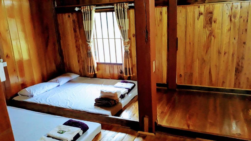 Habitación pequeña con cama y ventana en Nặm Pé Homestay en Bak Kan