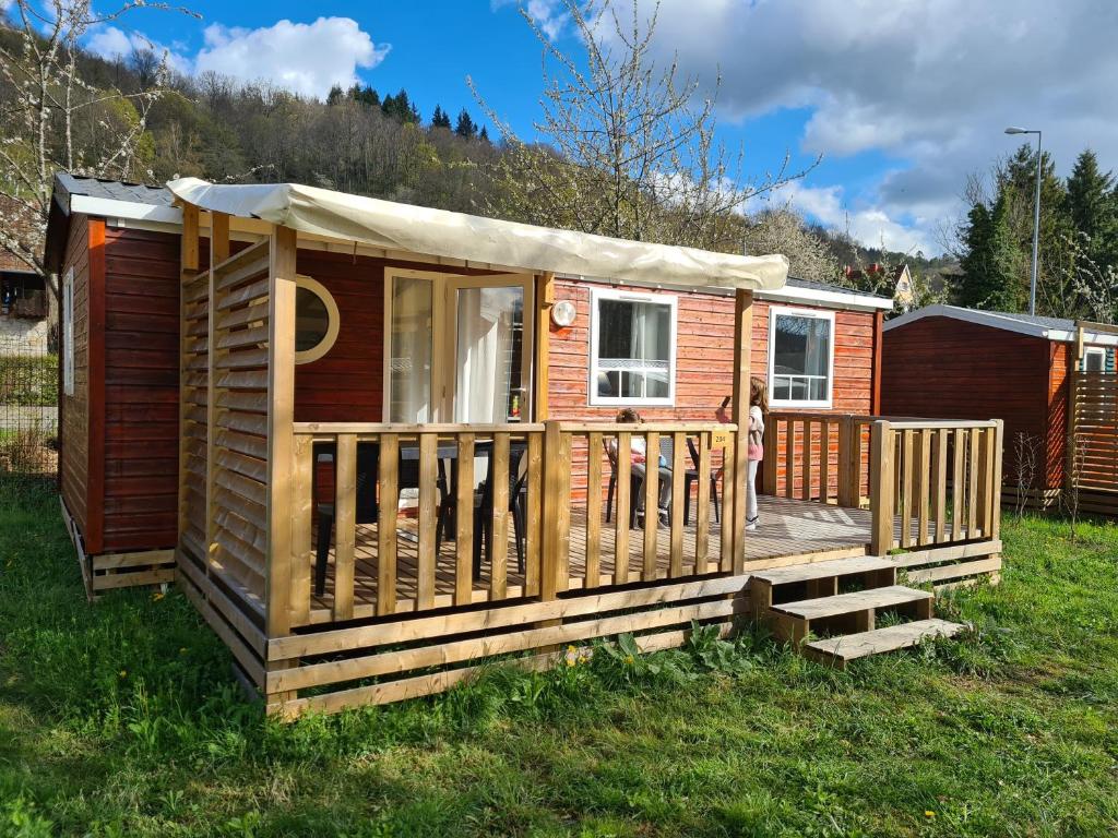 a wooden cabin with a deck in the grass at Cute house in Alsace in Munster