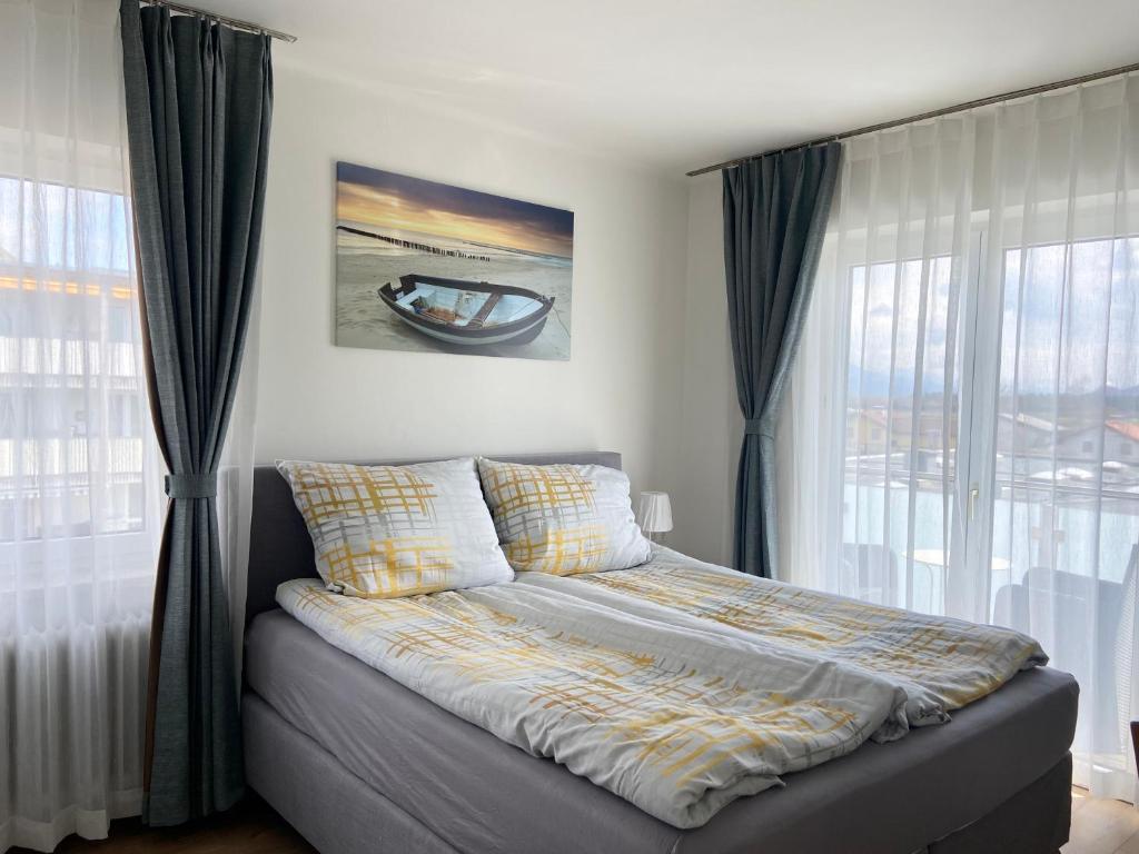 un letto in una camera da letto con tende e finestra di Wohnen mit Bergausblick a Wals-Siezenheim