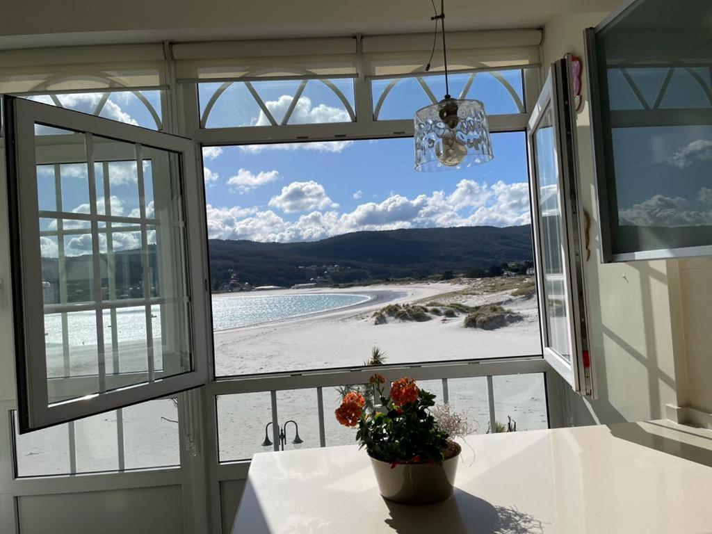 a window view of a beach from a house at Rompeolas in Laxe