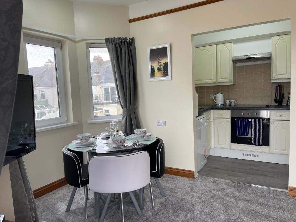 comedor con mesa y cocina en Eton Court Apartments en Newquay