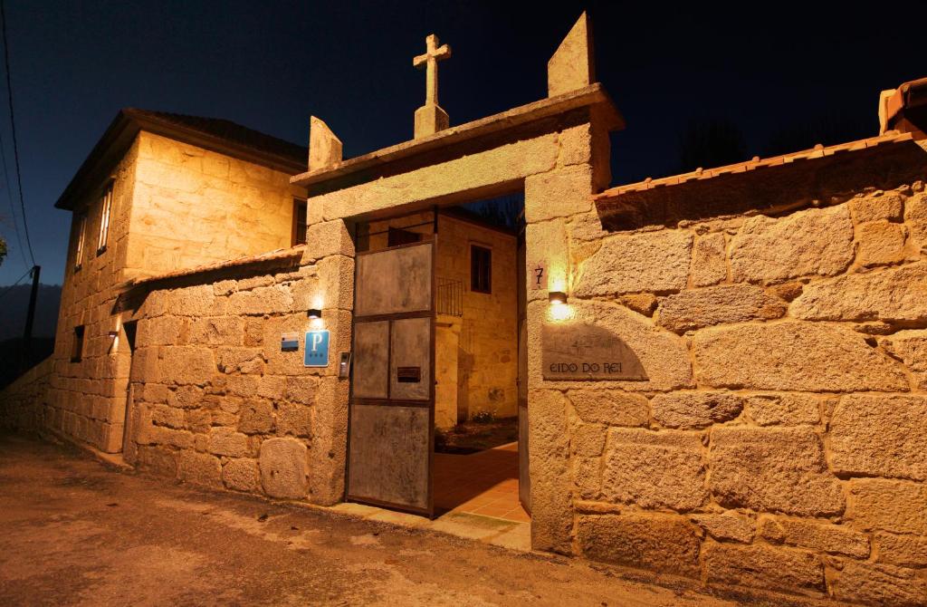 ein altes Steingebäude mit einem Kreuz darüber in der Unterkunft Eido do Rei - Hospedaxe rural in Ponteareas