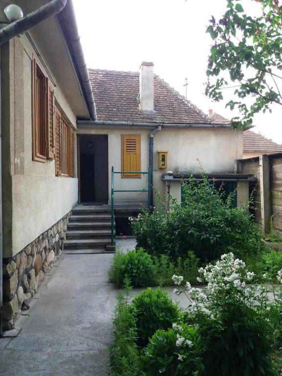 a house with a yellow door and stairs to it at Guest House - Wai derhim in Sibiu