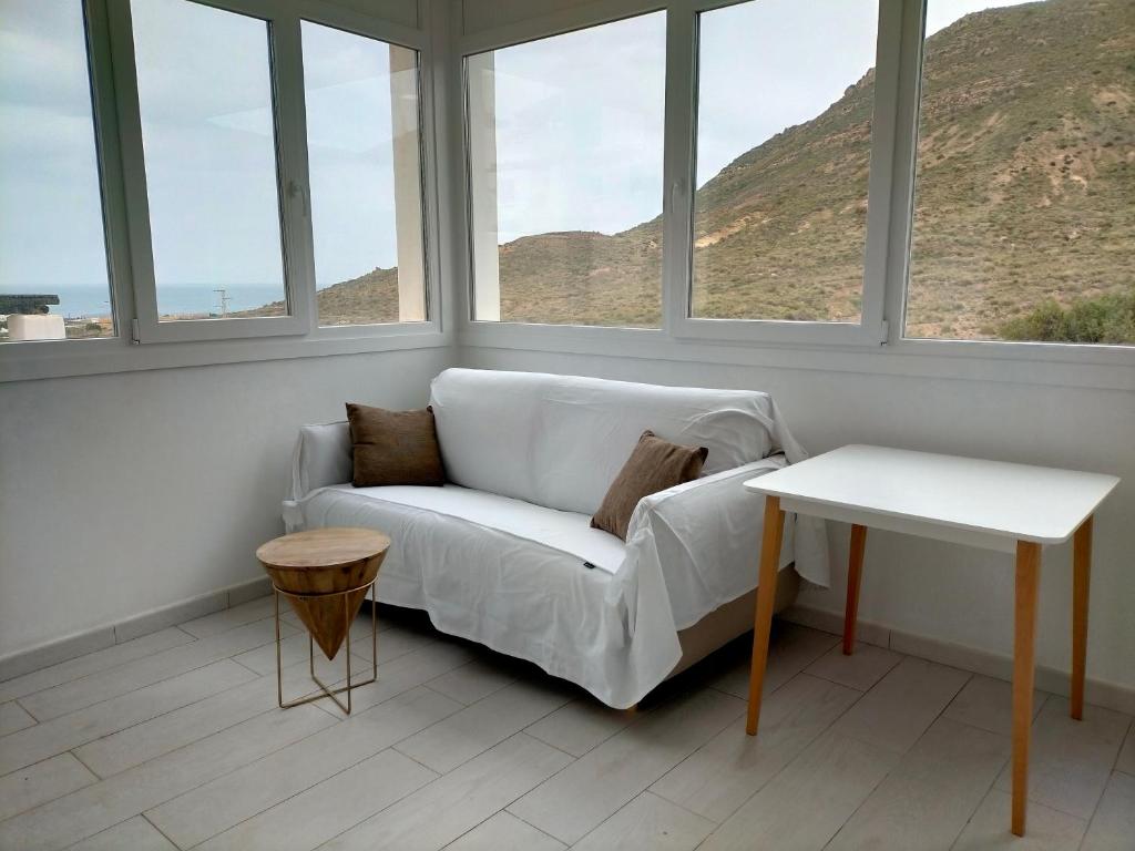 - un canapé blanc dans une pièce avec fenêtres dans l'établissement Loft con piscina comunitaria, à Las Negras
