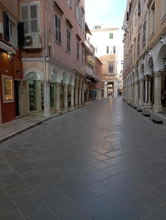 een lege straat in een stad met gebouwen bij Piccolo Centrale in Corfu-stad