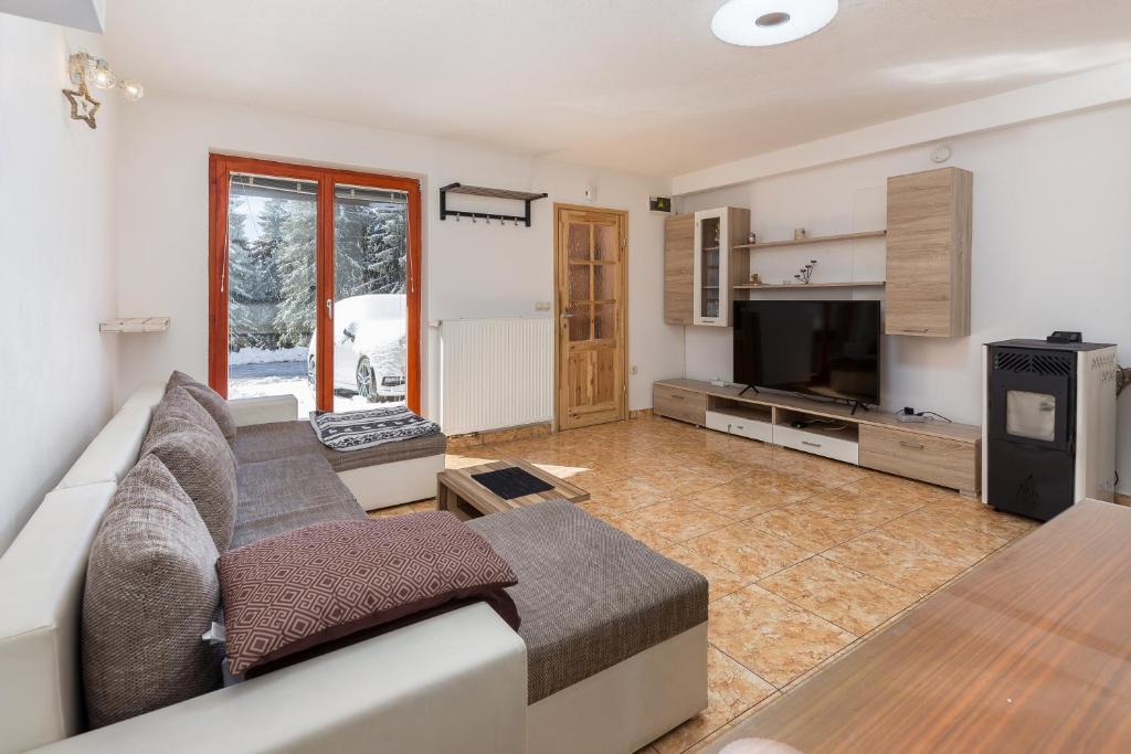 a living room with a couch and a tv at Apartma Valsar Rogla in Zreče
