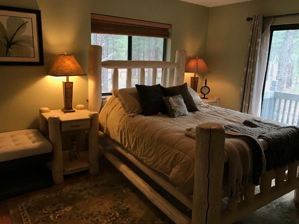 a bedroom with a wooden bed with two lamps and a window at Grand Canyon 1bd Loft/Suite-Horseback Riding-Shooting-Dogs OK! in Parks