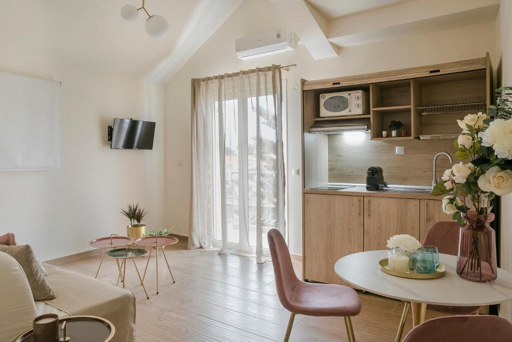 a living room with a table and a kitchen at Socrates Apartments in Skala Kefalonias