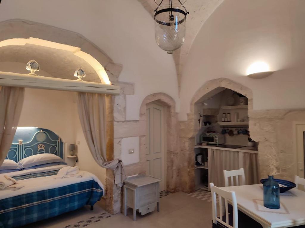 Schlafzimmer mit einem Bett und einem Tisch in der Unterkunft Antiqua Nova in Ceglie Messapica