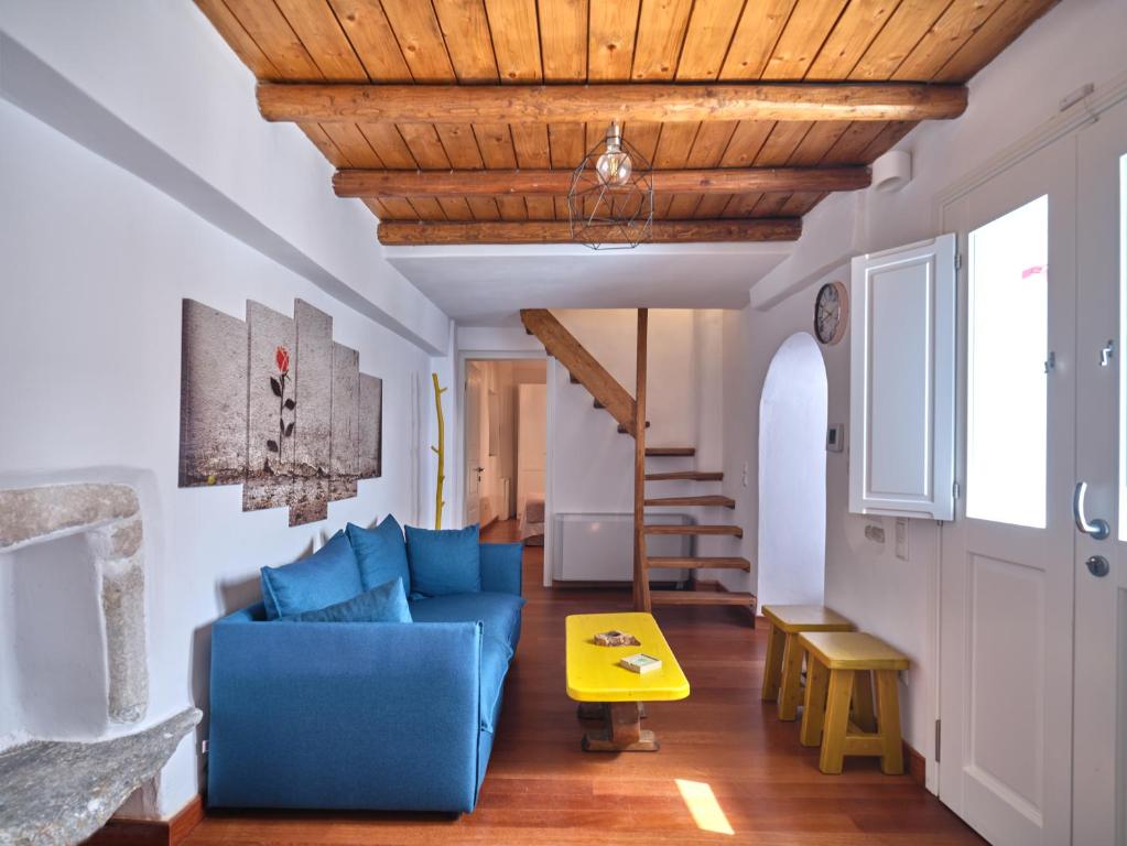 a living room with a blue couch and a wooden ceiling at Retreat Paros - The Happy Apartment in Parikia