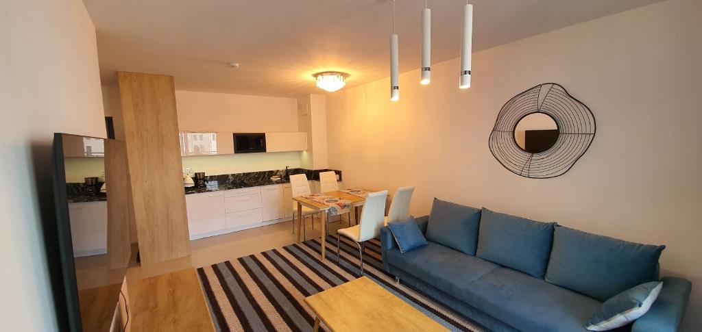 a living room with a blue couch and a table at Apartament Bel Mare in Międzyzdroje