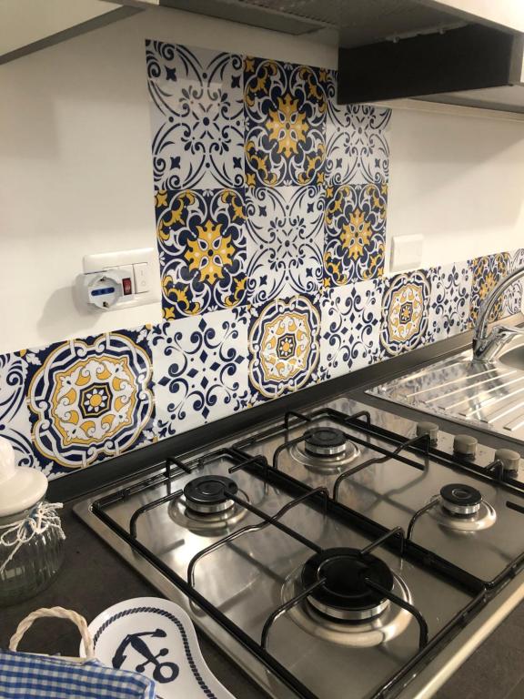 a kitchen with blue and white tiles on the wall at Monolocale Love Loft in Tropea