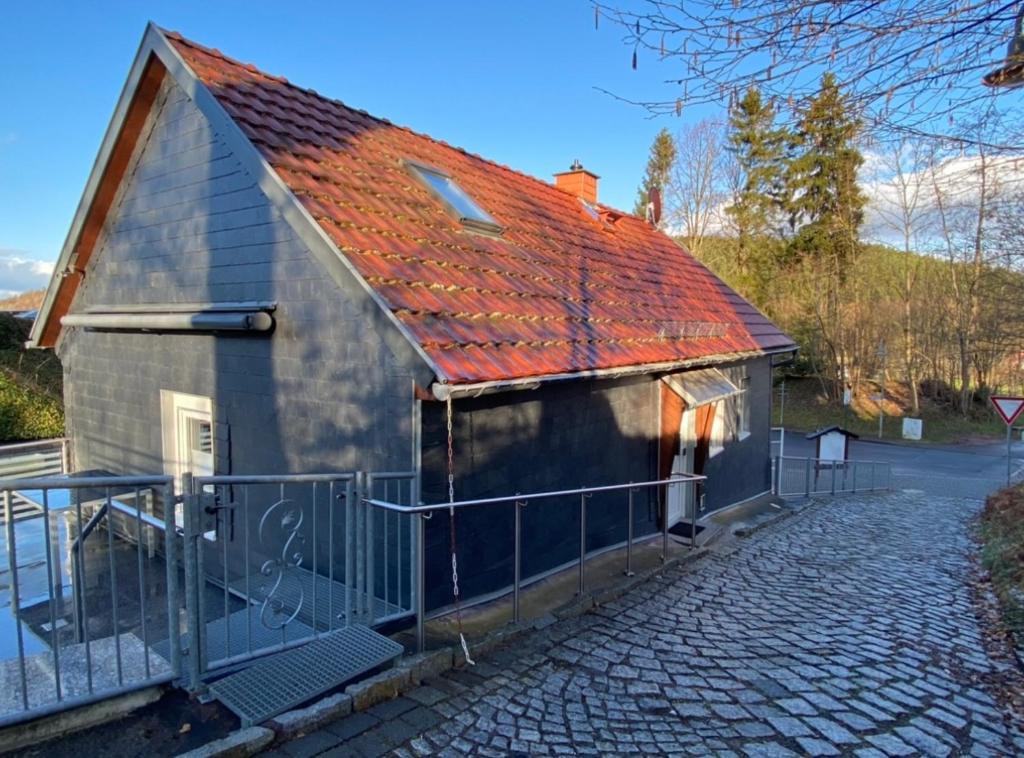 ein kleines Haus mit rotem Dach auf einer Straße in der Unterkunft Ferienwohnung Engelsbach in Engelsbach