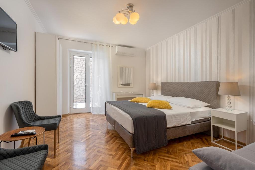 - une chambre avec un lit et une chaise dans l'établissement Apartment Banje Beach 3, à Dubrovnik
