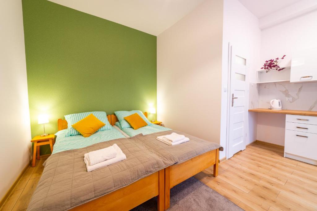 1 dormitorio con 1 cama grande y pared verde en Pokoje u Matiego, en Mikołajki