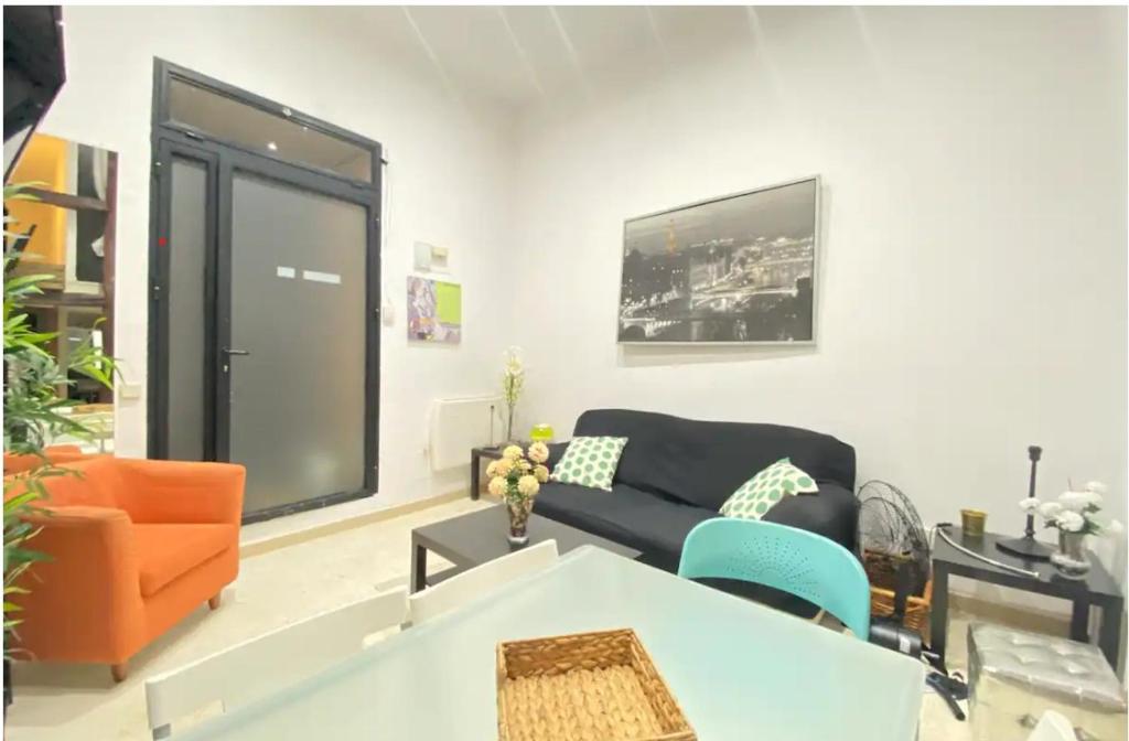 een woonkamer met een zwarte bank en oranje stoelen bij ILE BUENA VISTA EXTERIO in Madrid