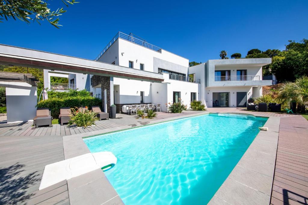 a villa with a swimming pool in front of a house at Villa Louancelie B&B in Cavalaire-sur-Mer