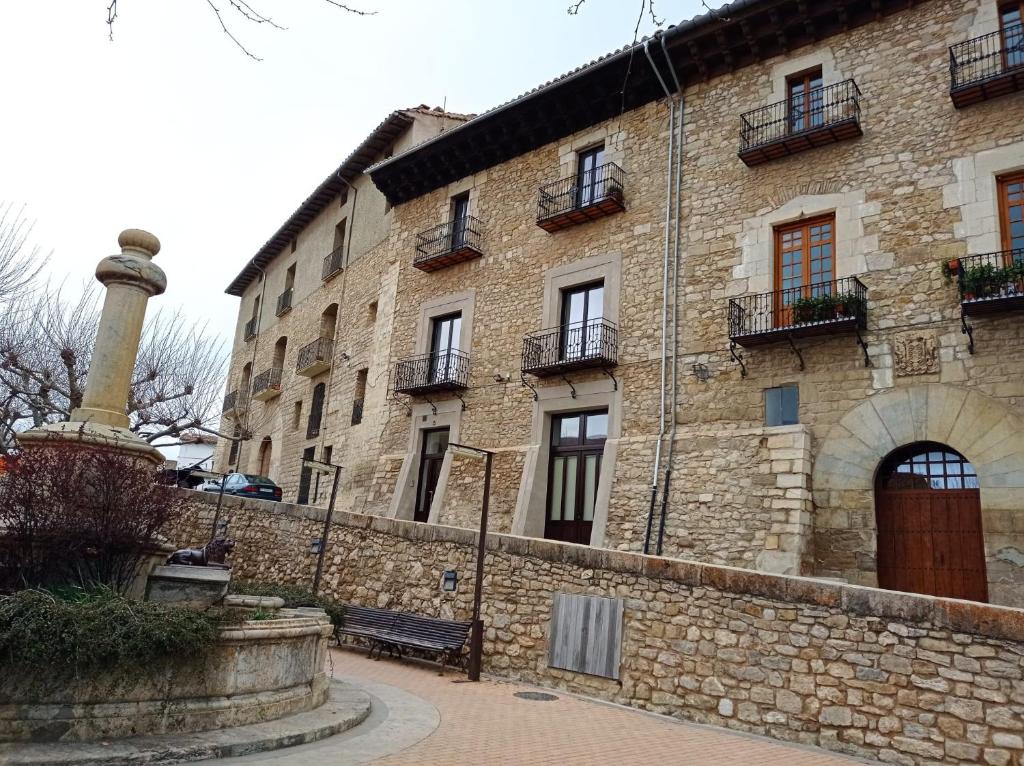 un gran edificio de piedra con una columna delante en Dúplex Dels Estudis, en Morella