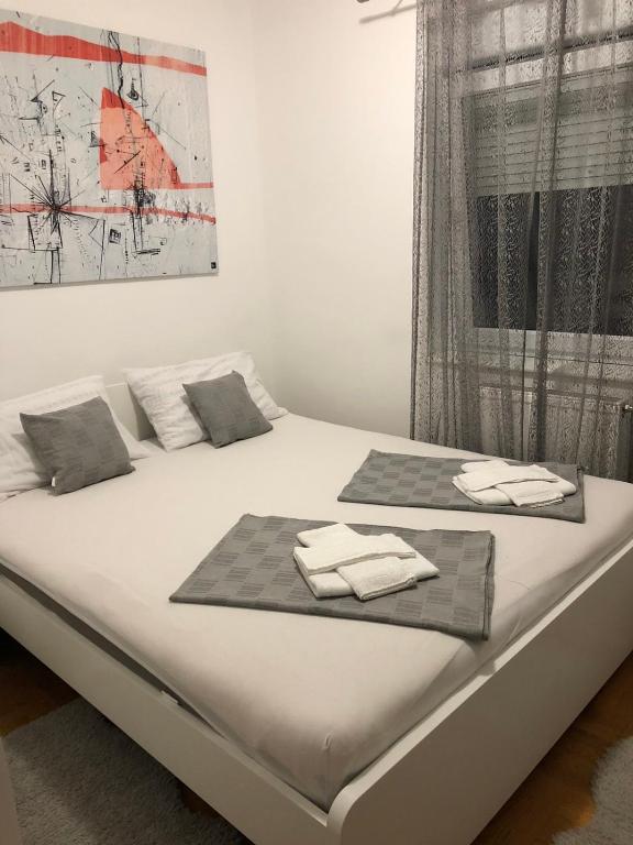 un letto bianco con sopra asciugamani di S-Lux apartman a Sombor