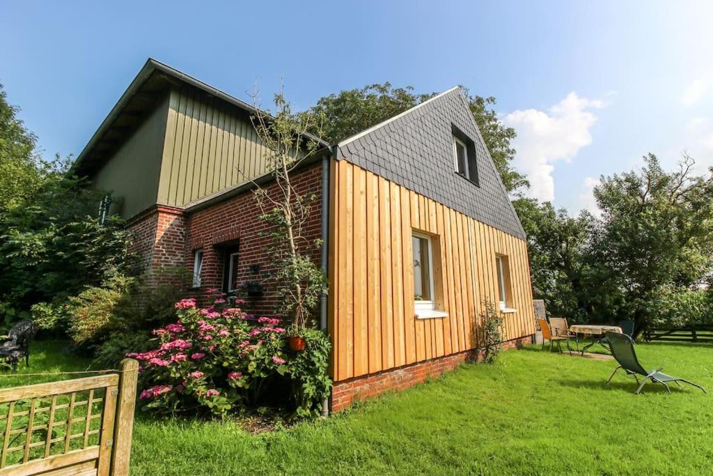 a small wooden house in a yard at Ferienhaus auf einer Warft in Tetenbüll