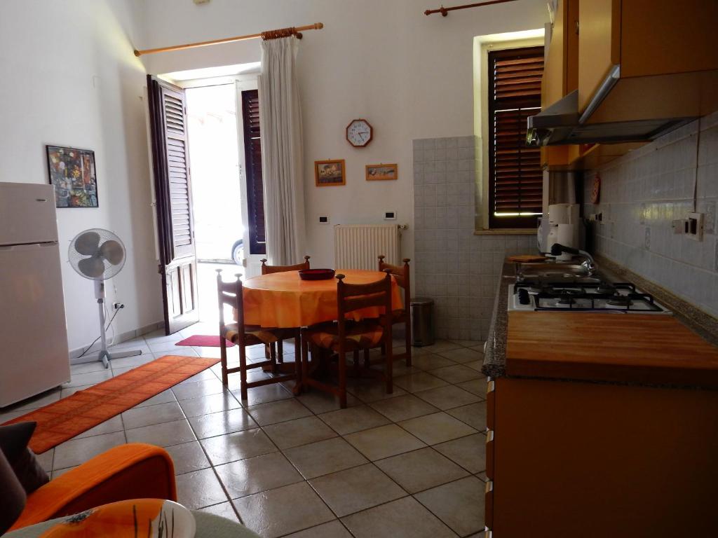 Terrasini Siracasa في تيراسيني: مطبخ مع طاولة وغرفة طعام