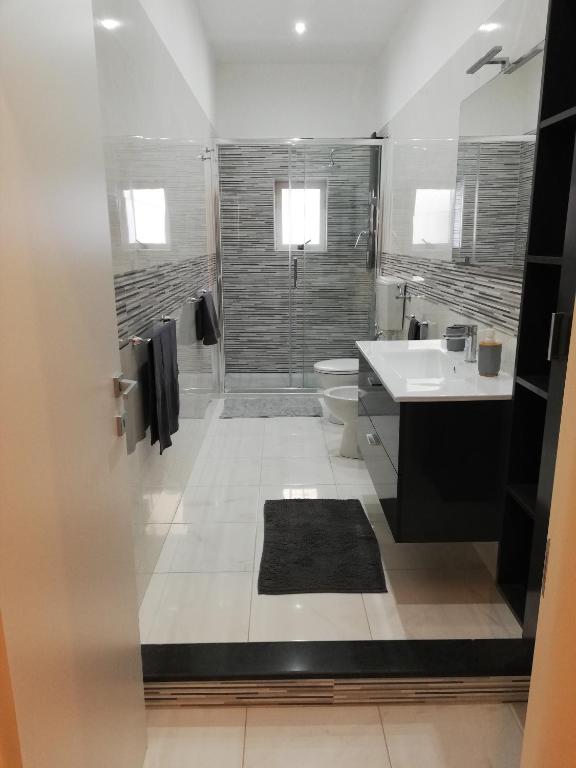 a bathroom with a shower and a toilet and a sink at Happy Home in Pozzallo