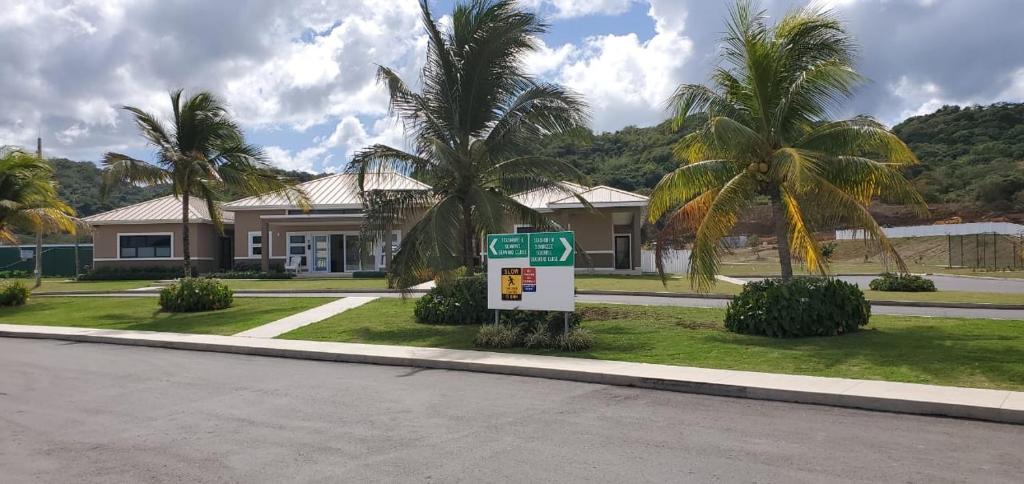 un panneau devant une maison plantée de palmiers dans l'établissement Jamaica Tranquility, à Lucea