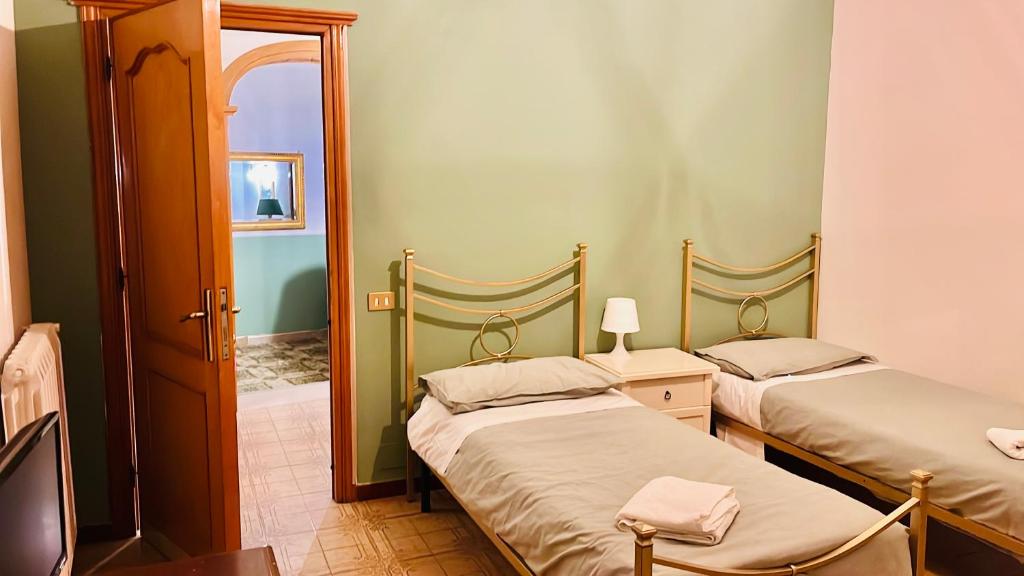 two twin beds in a room with a mirror at Airport Torre Clementina INN in Fiumicino