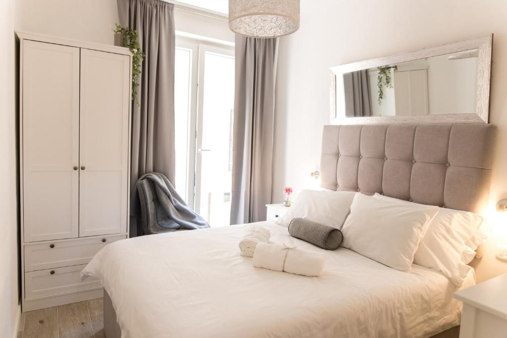 The Perfect Room Zadar في زادار: غرفة نوم مع سرير أبيض كبير مع مرآة كبيرة