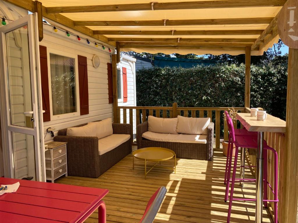 a patio with a table and chairs on a deck at Le Lolipop in Capbreton