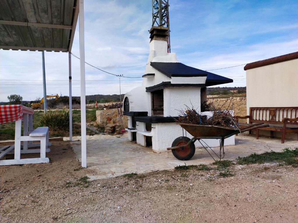 a small white chapel with a wheelbarrow in front of it at Era 124 in Zafra de Záncara