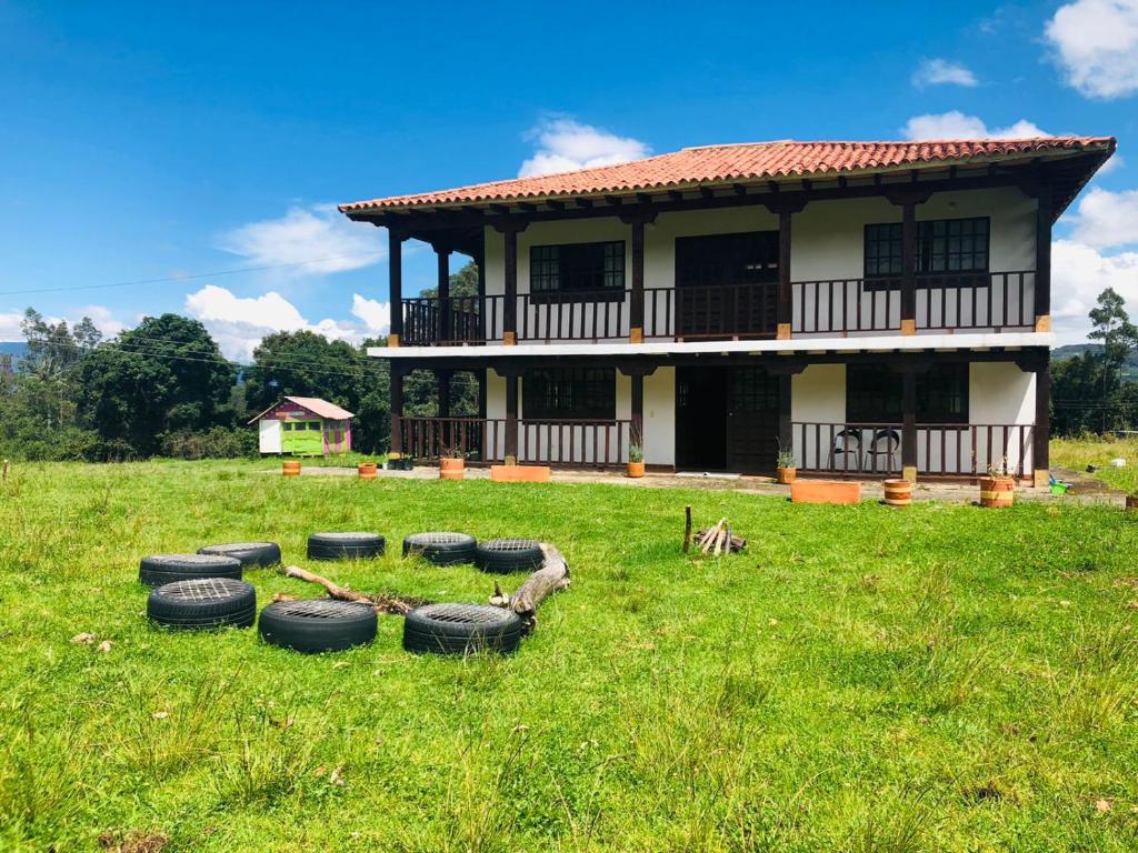 ein Haus mit Reifen im Gras davor in der Unterkunft El Pentagono Verde in Arcabuco