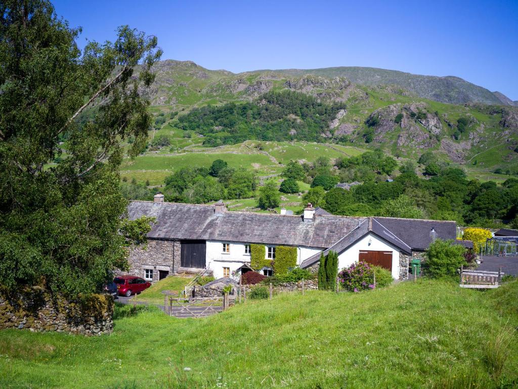 a house on a hill with mountains in the background at Kentmere Fell Views in Kendal