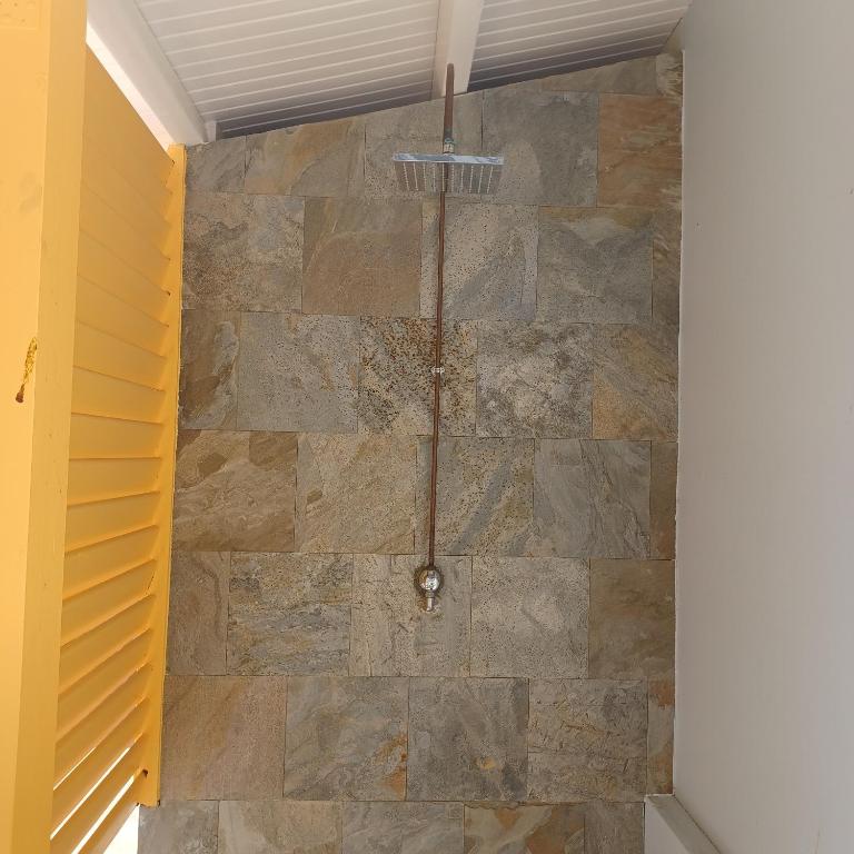 bagno con parete in pietra di Maison de vacances les pieds dans l'eau a Schœlcher