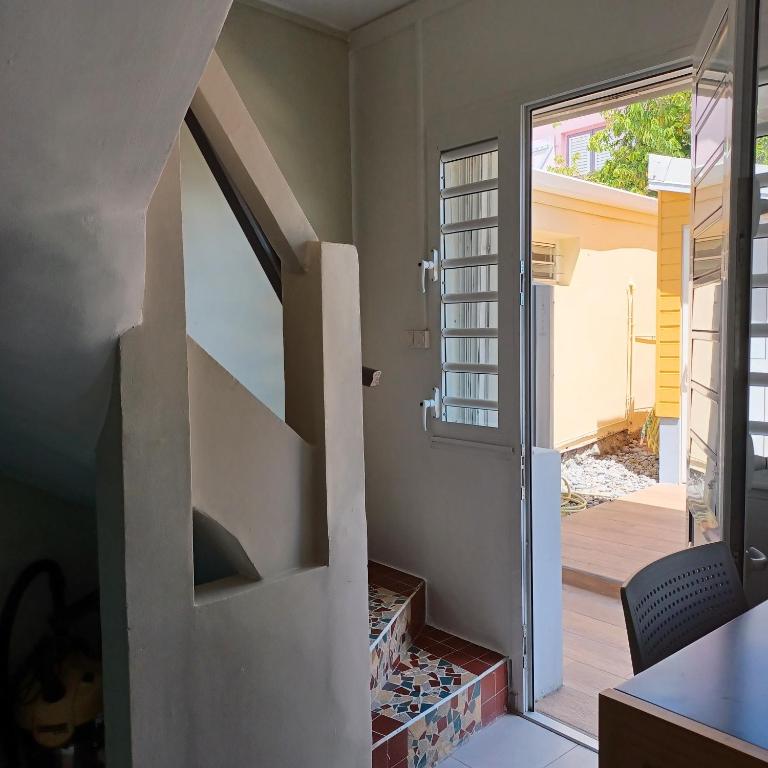 una scala che conduce a una casa con porta in vetro di Maison de vacances les pieds dans l'eau a Schœlcher