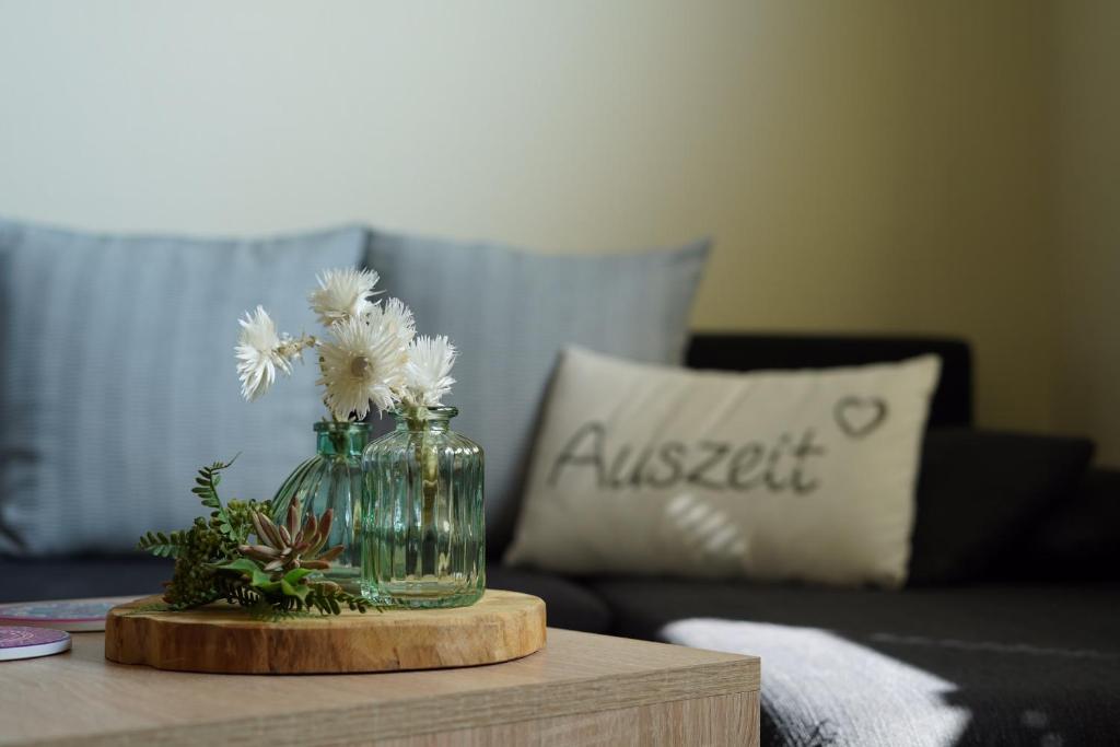 a vase with white flowers in it on a table at Auszeit - Ferienwohnung und Appartements in Bad Sooden-Allendorf
