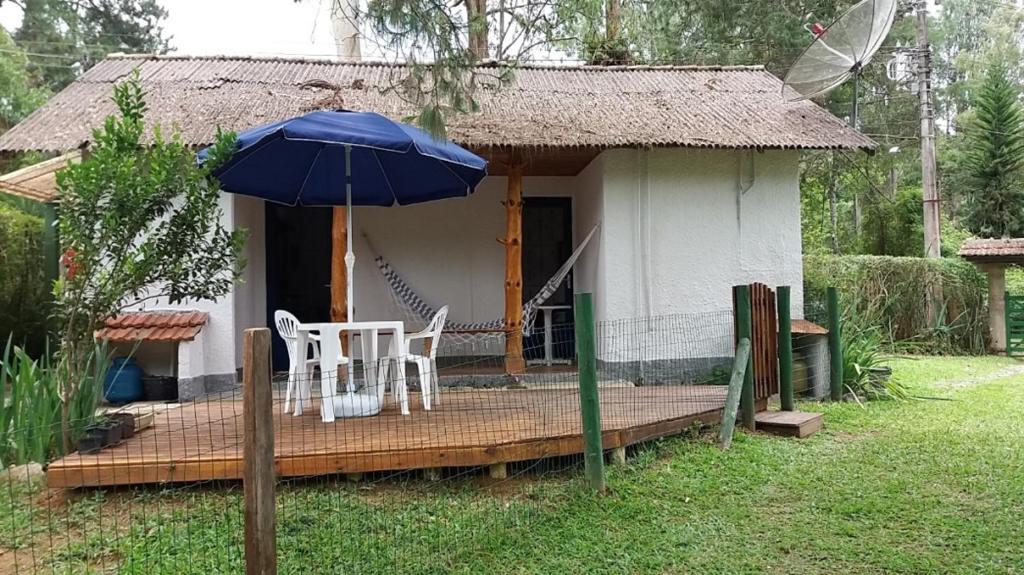 博凱納迪米納斯的住宿－Chalé Honeycomb em Visconde de Mauá，一座带两把椅子和一把伞的小房子