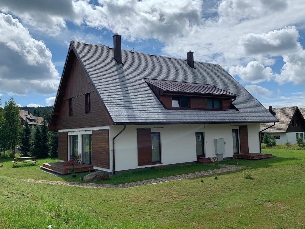 una casa con techo de gambrel en un campo de hierba en Naše Borovka, en Borová Lada