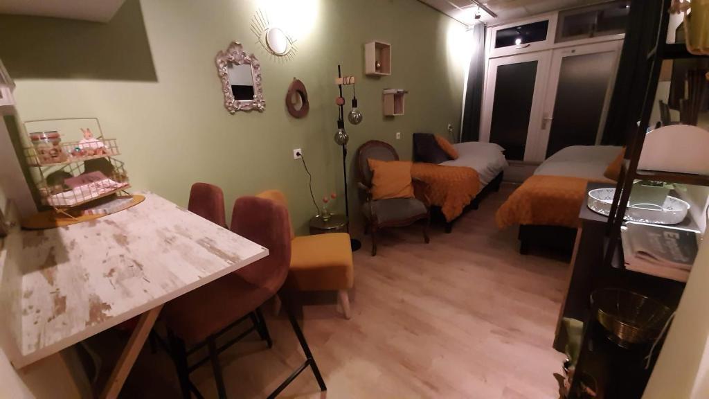 een kamer met een kamer met een bed en een tafel bij Gastenverblijf Nummer 1 Sommelsdijk in Sommelsdijk