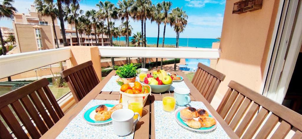 a table with food on a balcony with a view of the ocean at Apartamento Flamingo by DENIA COSTA in Denia