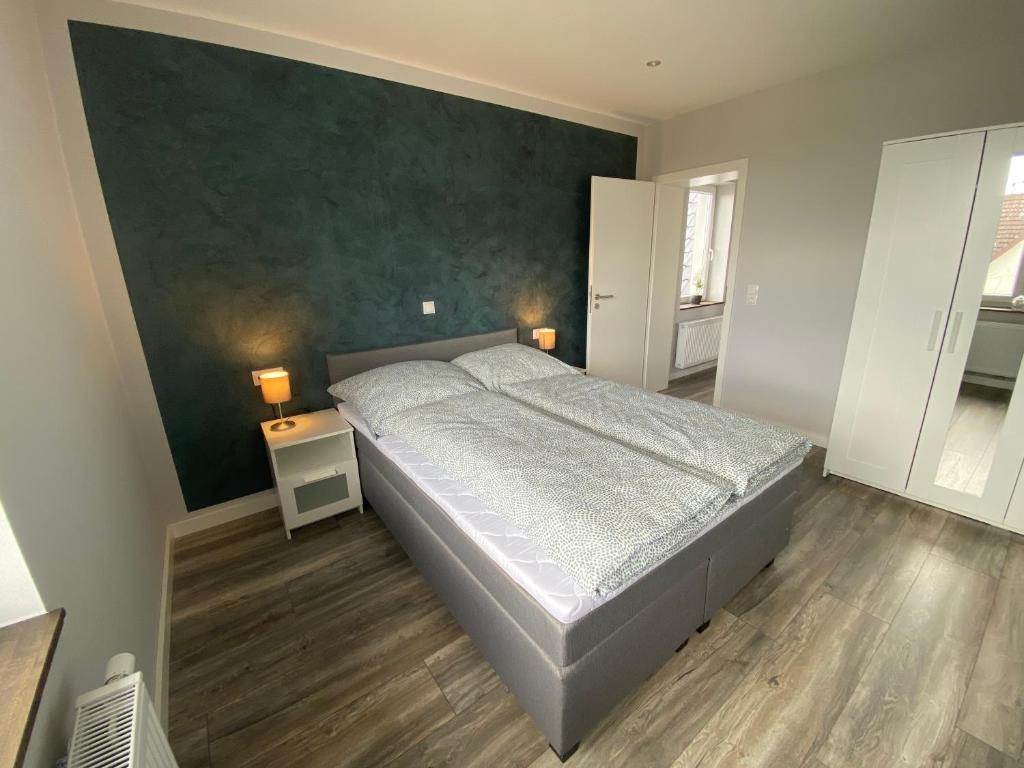 - une chambre avec un lit et un mur vert dans l'établissement Design Apartment Sasaki, à Celle