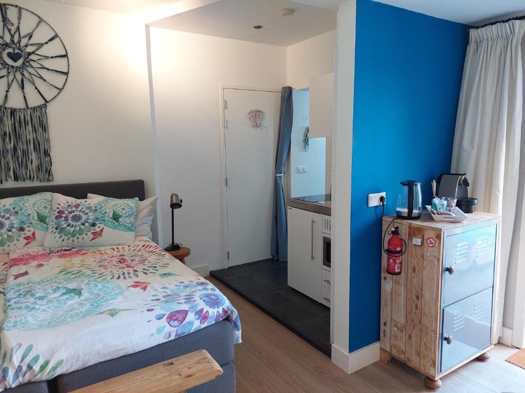 una camera con letto e parete blu di Studio Pipper a Zandvoort