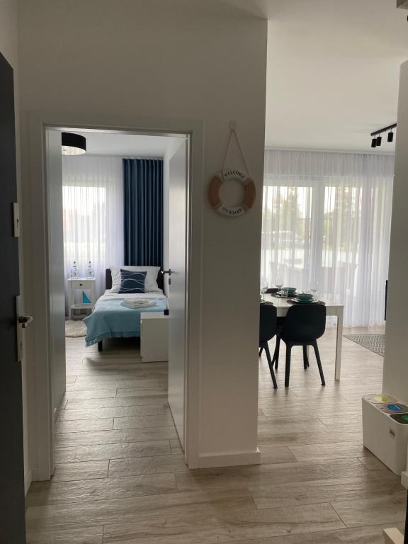 sypialnia z łóżkiem i pokój ze stołem w obiekcie Apartament BLUE Rewal w Rewalu