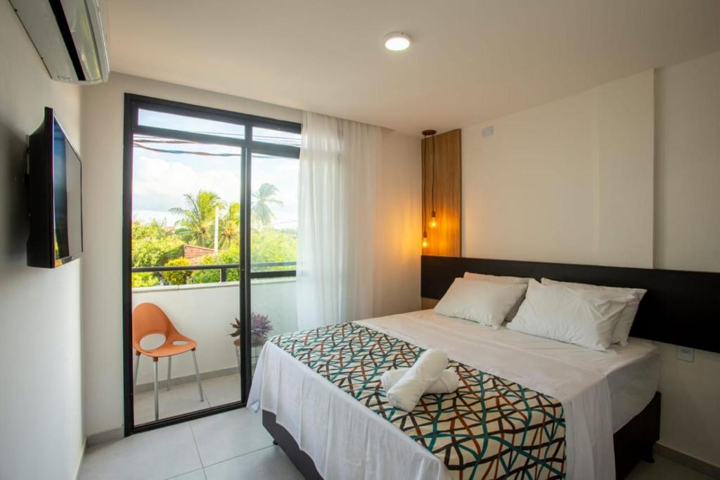 a hotel room with a bed and a balcony at Pousada Terra do Vento in São Miguel do Gostoso