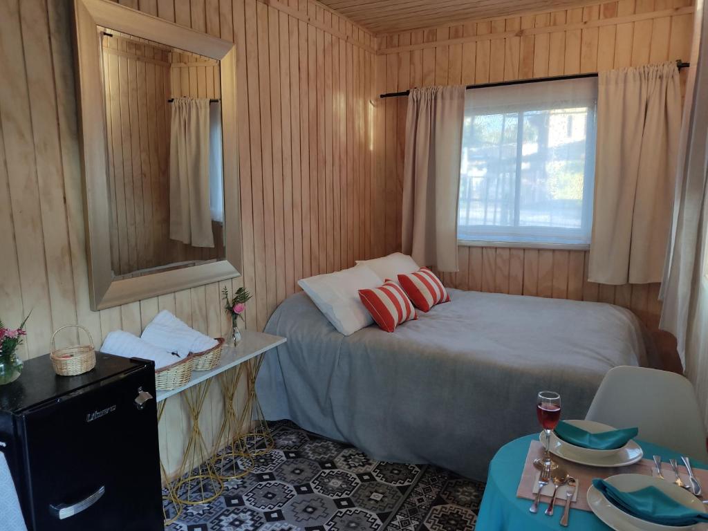 a small bedroom with a bed and a window at Cabaña vista al volcán en centro de Pucón in Pucón