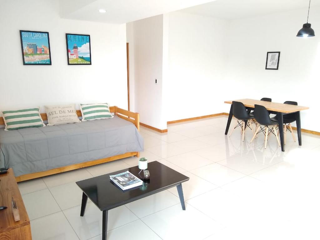 a living room with a bed and a table at Buenaventura Apartment in Mendoza
