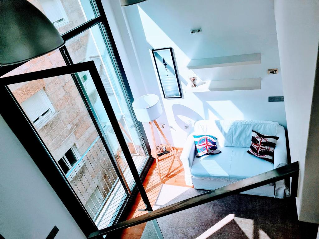 een woonkamer met een stoel en een raam bij El Camarote del Fraga Apartamento en pleno centro de Vigo con parking in Vigo